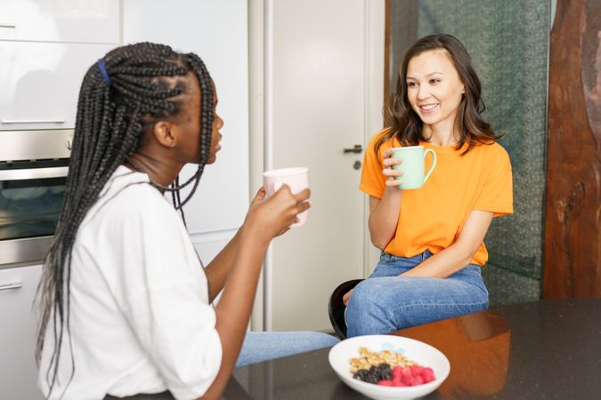 Two women chatting over coffee in the kitchen