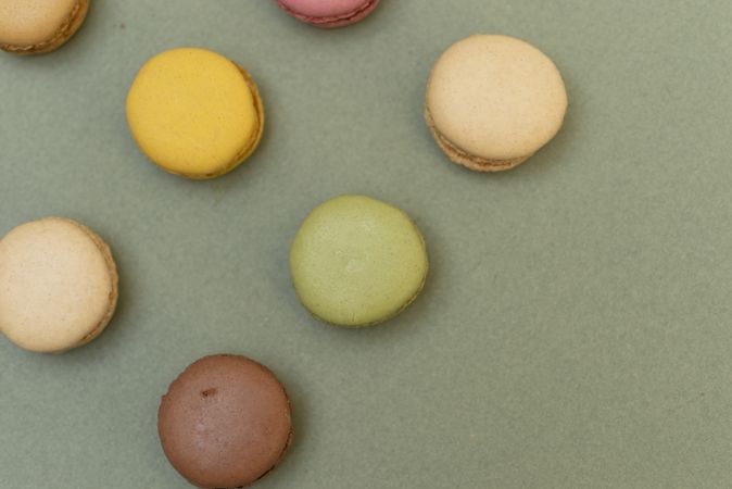 Rows of macaroons on green table from above