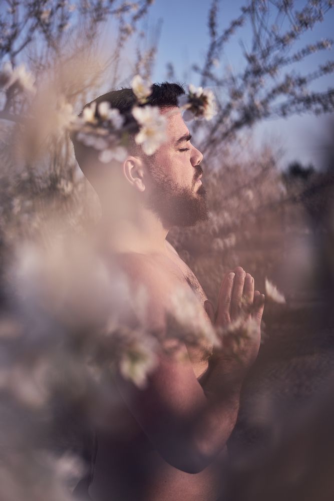 Shirtless man meditating in spring garden