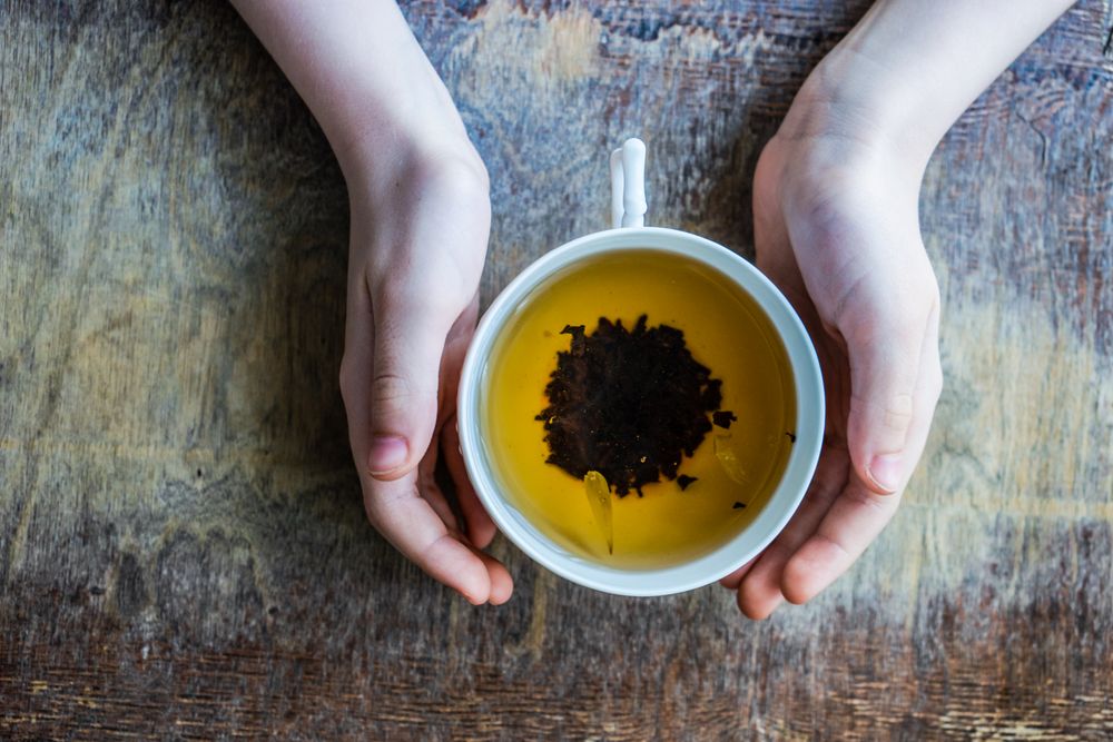 Hands surrounding cup of tea