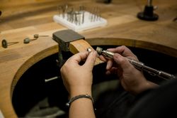 unrecognizable woman grinding ring in jewelry atelier