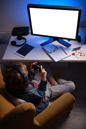 Unrecognizable kid playing on computer at home
