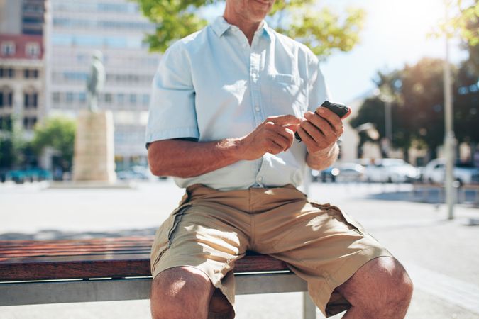Cropped shot of  man sitting outdoors on a bench