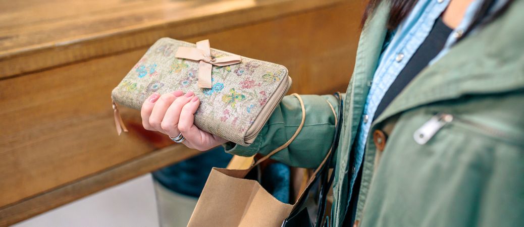 Banner of unrecognizable woman client holding wallet and ecological shopping paper bags on store