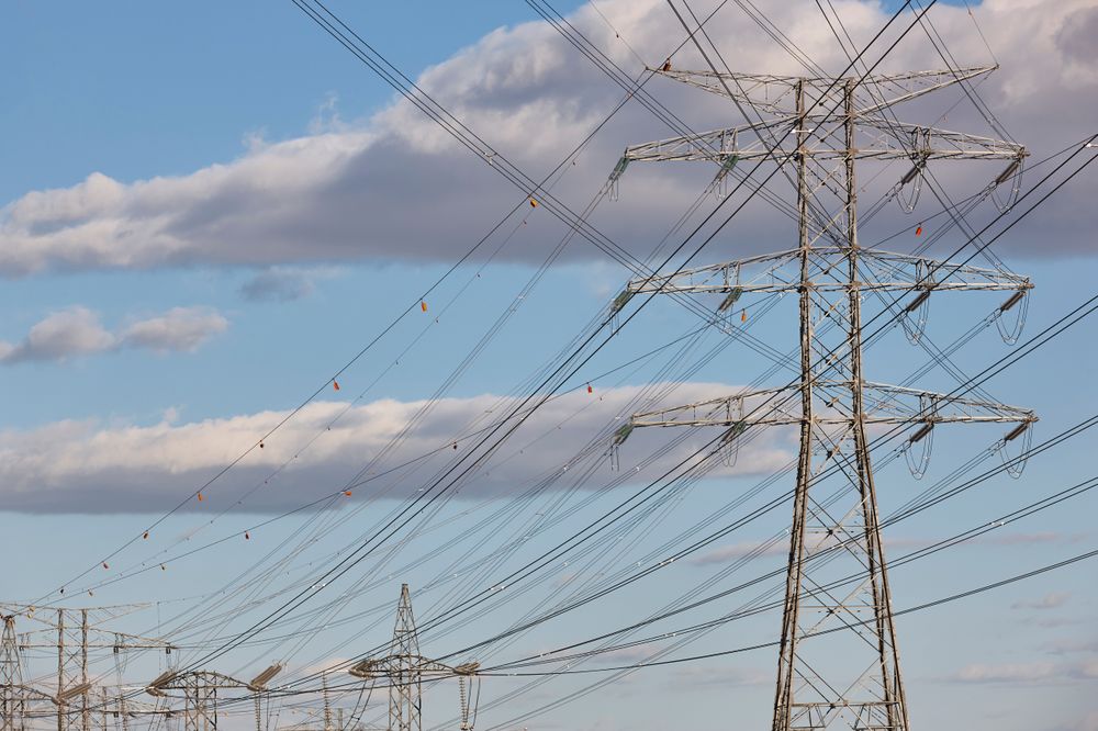High-Voltage Power Lines and Transmission Towers Against Blue Sky