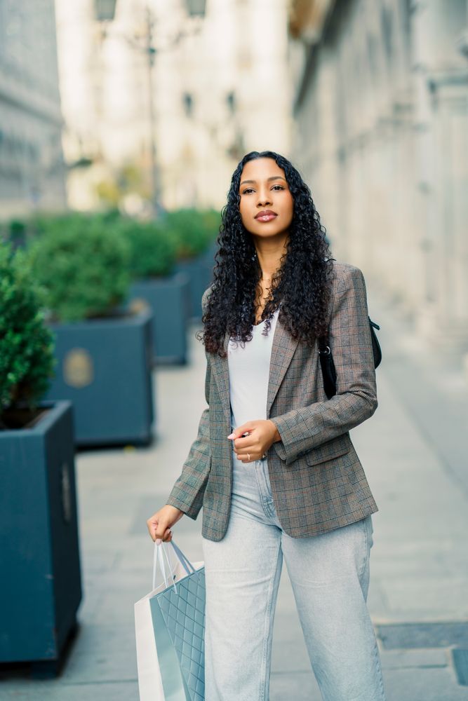 A Stylish Young Woman Enjoying Shopping in a Vibrant Urban Setting Full of Life and Fashion