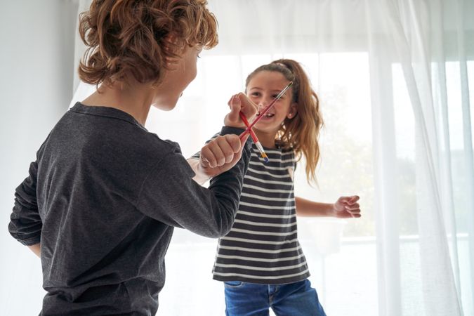 Boy and girl playing with paintbrushes
