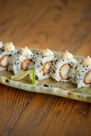 Delicious sushi rolls on plate placed on table