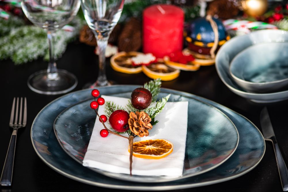Blue Christmas table setting with decorative berries and dried orange slice