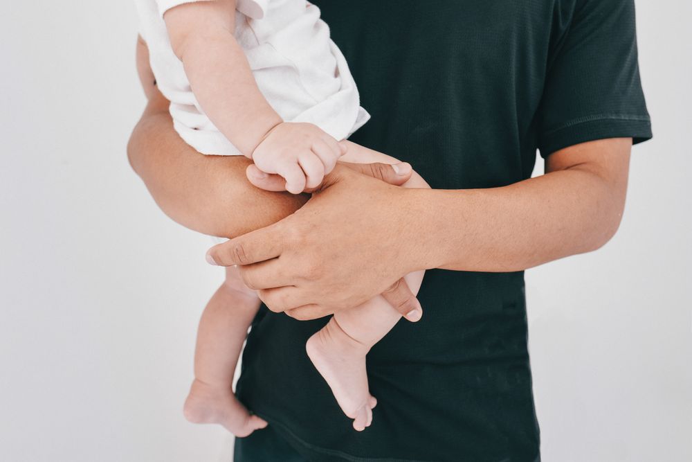 Anonymous man holding a baby