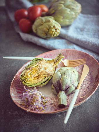 Artichokes with herbs near tomatoes