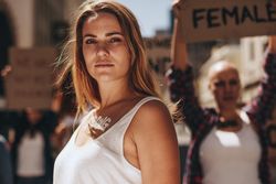 Woman activist with word strong written on her body standing outdoors