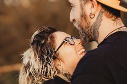 Happy couple hugging near tree in park