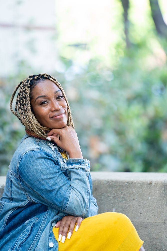 Portrait of beautiful woman sitting outside with her hand under her chin