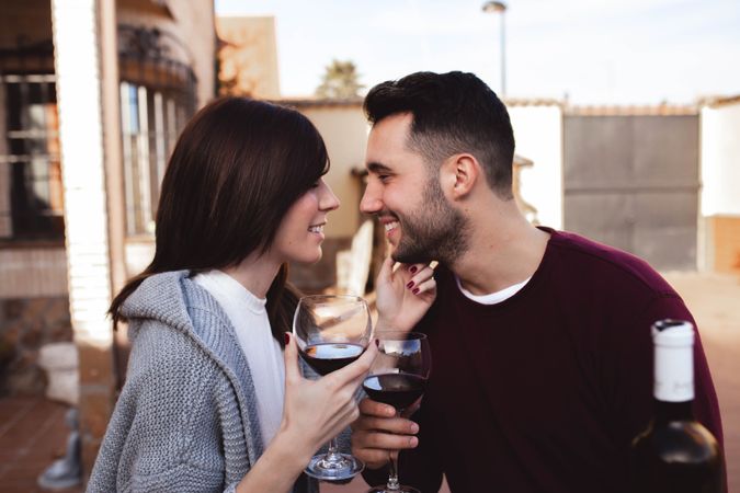 Happy couple drinking wine on terrace