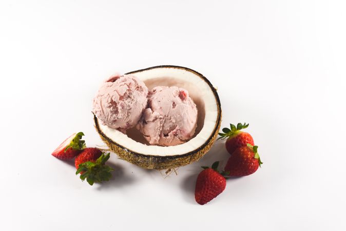 Top view of coconut shell with strawberry ice cream and fruit halves