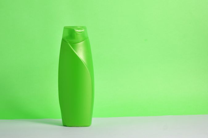 Green body wash bottle with no labels on counter in green room