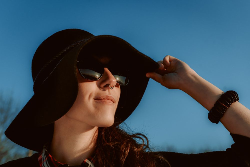 Dreaming stylish woman in sunglasses and hat