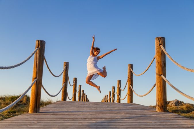 Woman posing in air on footbridge