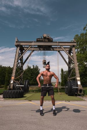 Black guy with barbell in outdoor gym
