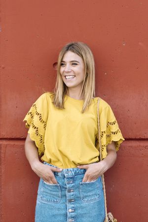 Cheerful woman standing on orange background