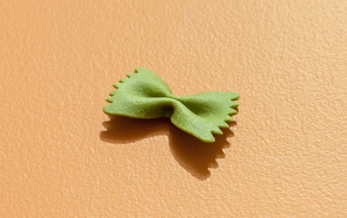 Spinach farfalle pasta minimalist on an orange table