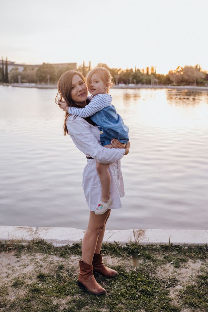 Mother and daughter standing near water