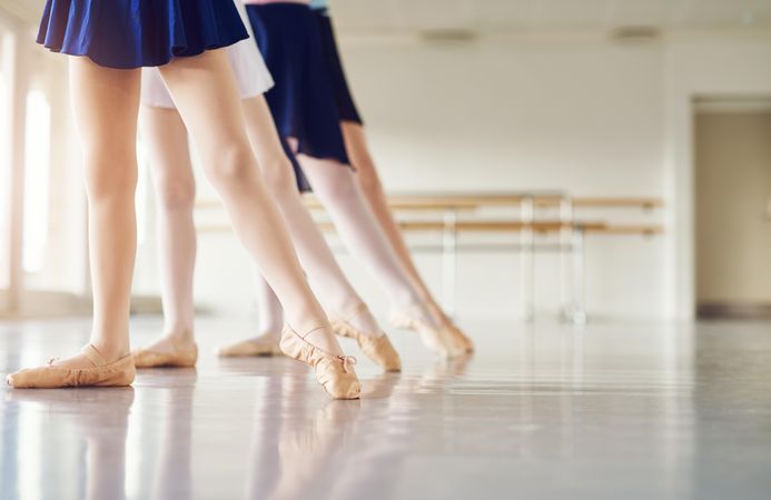 Line of girls’ legs pointing in ballet class