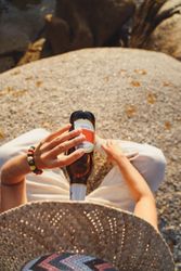 Woman relaxing and drinking beer at beach