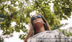 Woman with sunglasses standing over nature background 4MGNr1