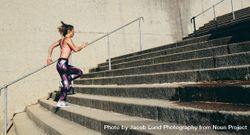 Side view shot of female runner athlete going up stairs 5ojrm0