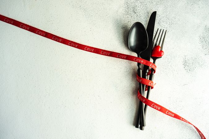 St. Valentine day concept of cutlery wrapped in red ribbon