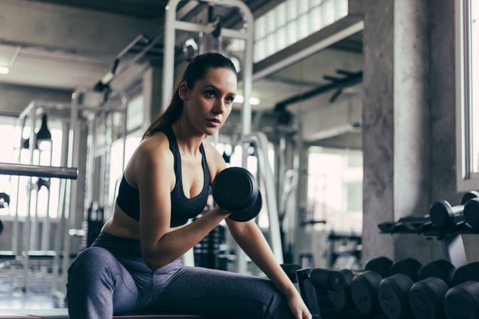 Fit woman lifting dumbbell in gym