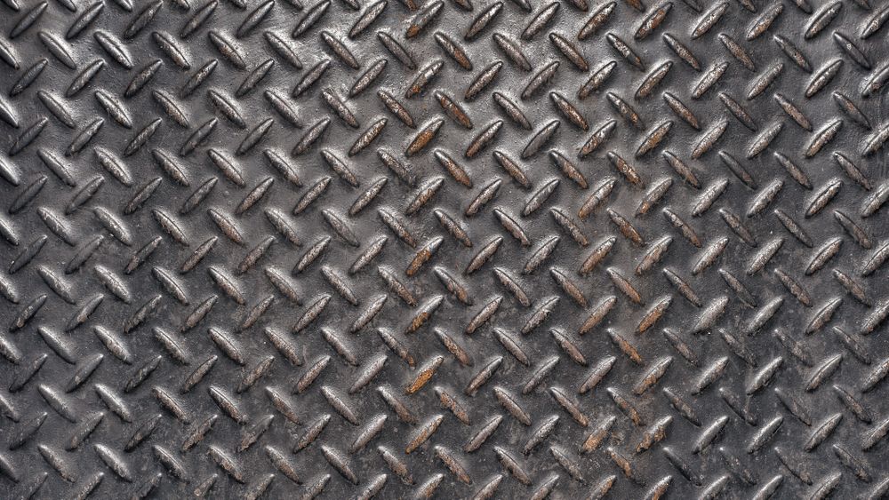 Dark steel floor plate with diamond pattern and industrial texture