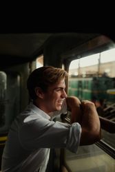 Cheerful traveler looking out train window