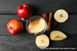 Top view of glass of water with straw, apple slices and cinnamon slices 4ZWZWb