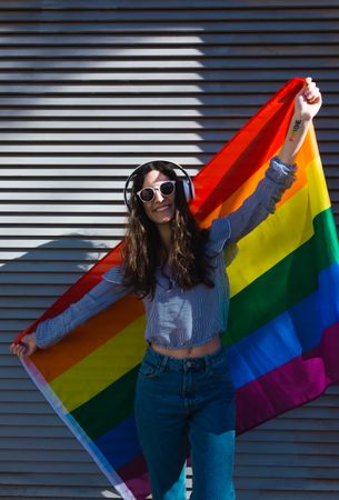 Happy white woman posing happily with the LGBT flag