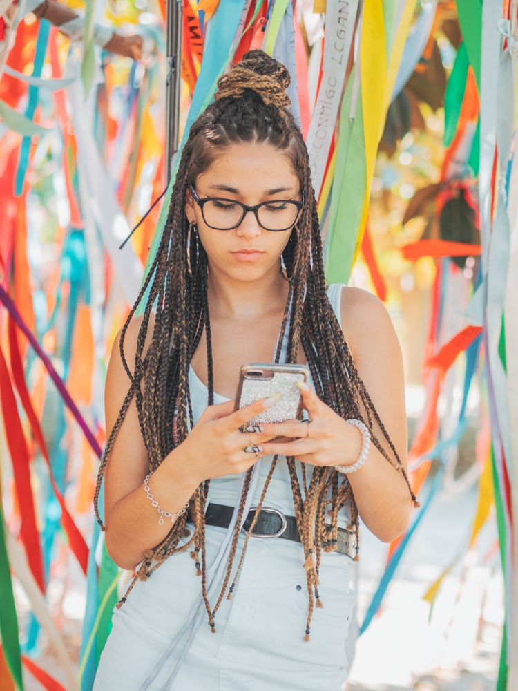 young woman using smartphone outside during festival