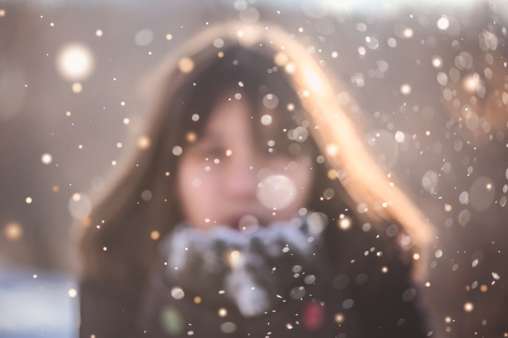 Blurry view of woman blowing snow