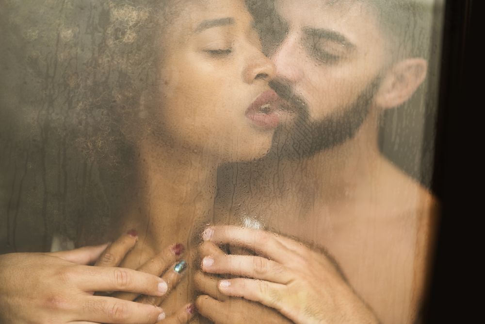 Bearded man touching girlfriend behind window
