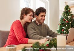 Young couple at home shopping online for christmas 0JGW6r