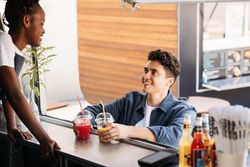 Man buying two fresh juices from food truck vendor