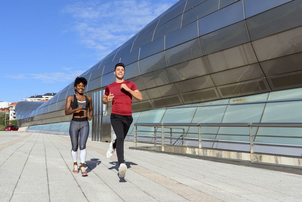 Modern active sportspeople running in city