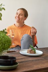 Happy woman enjoying delicious snack in kitchen