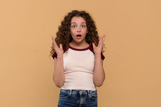 A surprised young girl with curly hair, expressing shock