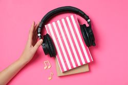 Concept of audiobook with books and headphones, top view