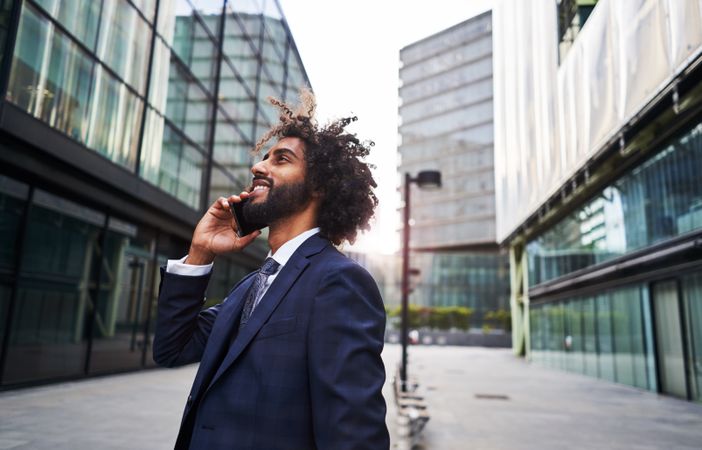 Curly man smiling at street
