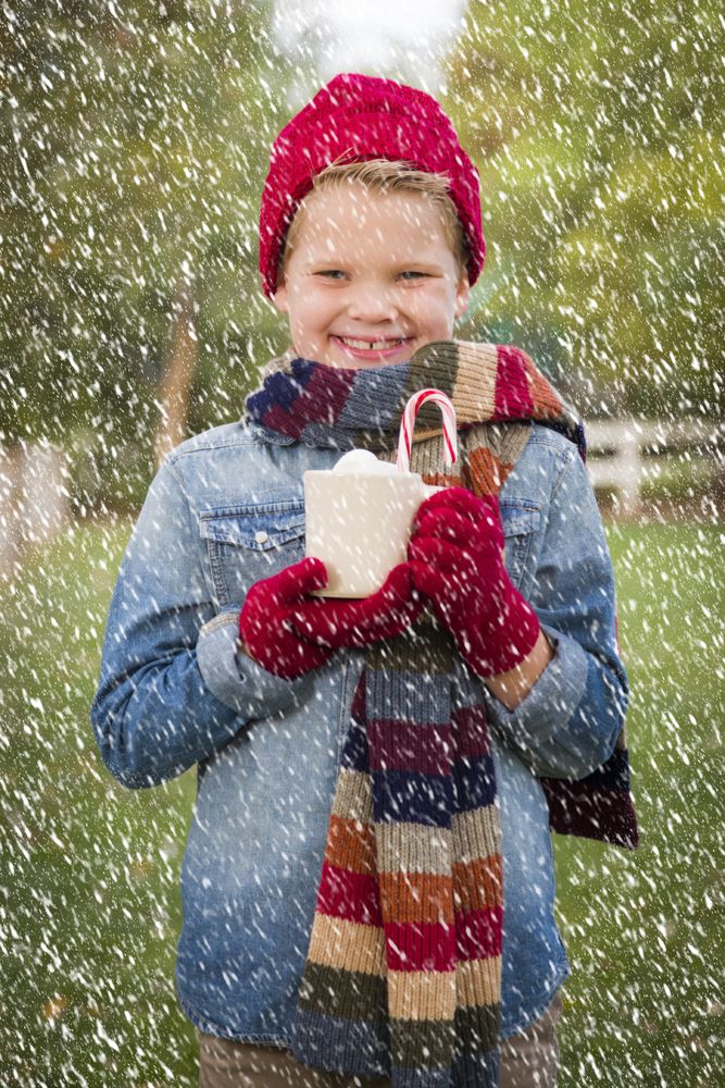 Young Boy in Warm Clothing Holding Hot Cocoa Mug Outside