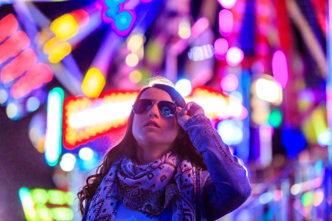 Stylish young woman near illumination on street