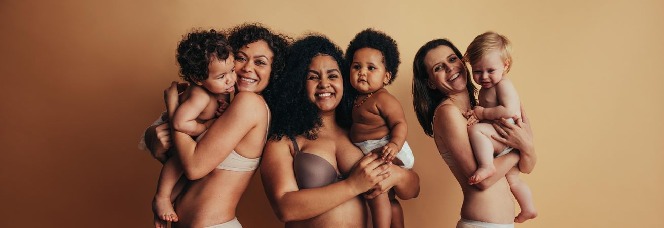 Proud mothers with postpartum bodies holding their babies